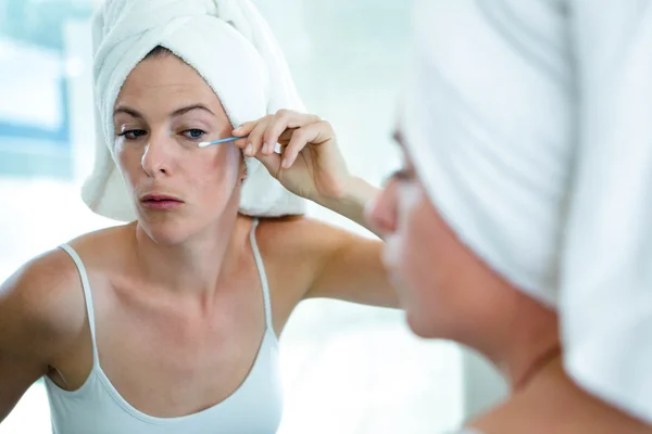 Vrouw met behulp van een wattenstaafje om haar mascaara vast te stellen — Stockfoto