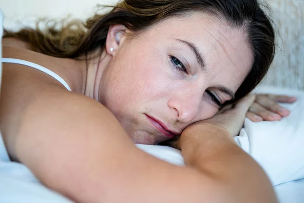 Schläfrige Frau in ihrem Bett sieht gefesselt aus — Stockfoto