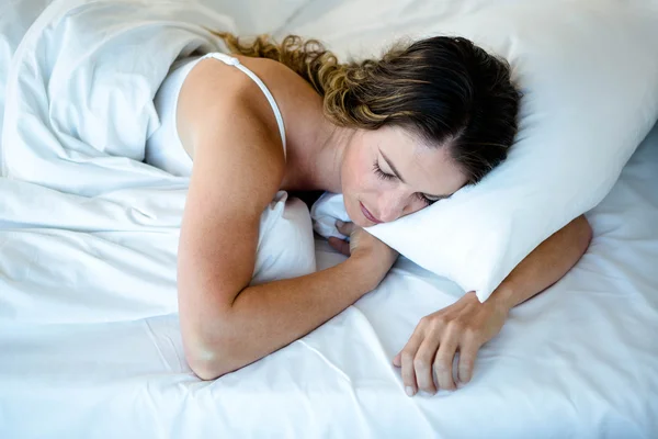 Мирная женщина спит в своей постели — стоковое фото