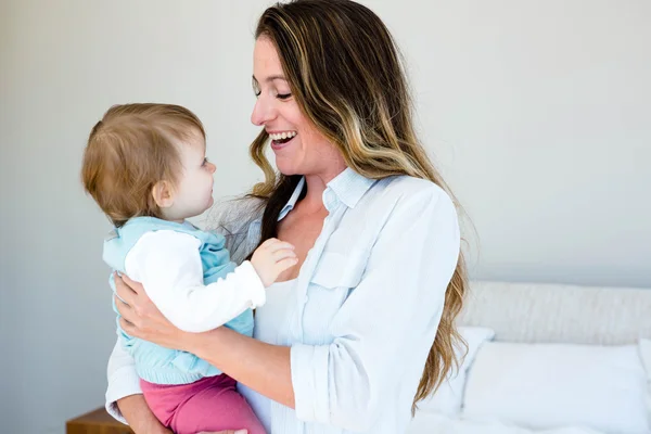 Smiling woman holding an adorable baby — Stock Photo, Image