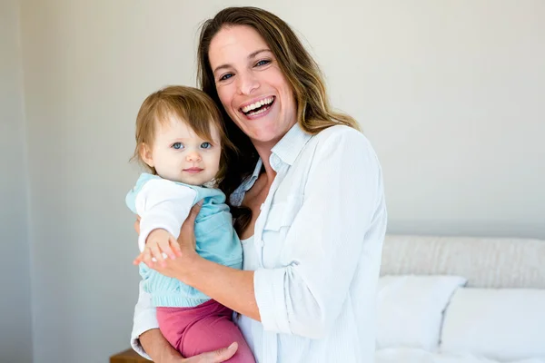 Smiling woman holding an adorable baby — Stock Photo, Image