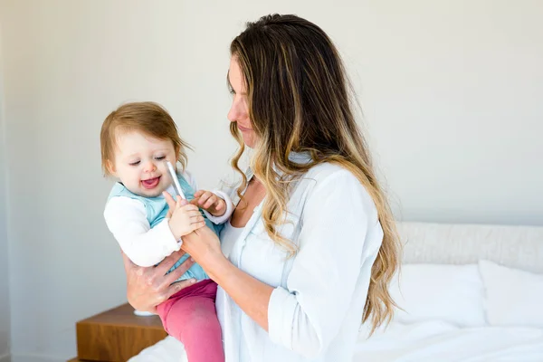 Hermosa mujer sosteniendo un adorable bebé — Foto de Stock