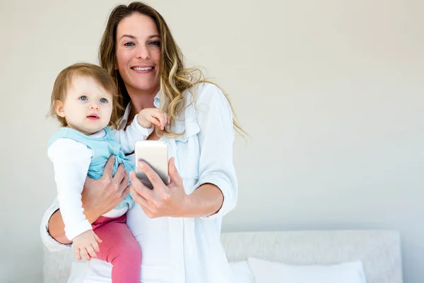 Sorrindo mulher tomando uma selfie com um bebê — Fotografia de Stock