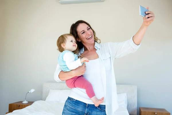 Smiling woman taking a selfie with her baby — Stock Photo, Image