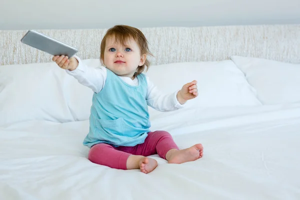 Modré oči dítě drží mobilní telefon — Stock fotografie