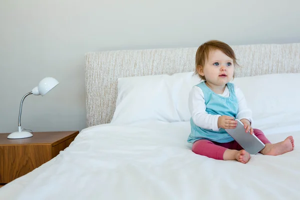 Schattig baby zittend op een bed — Stockfoto