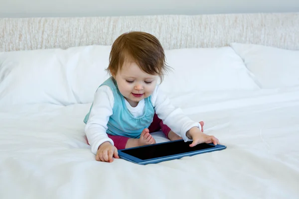 Bebé sonriente jugando con una tableta — Foto de Stock