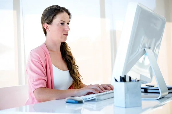 Вдумчивая деловая женщина, печатающая на компьютере — стоковое фото