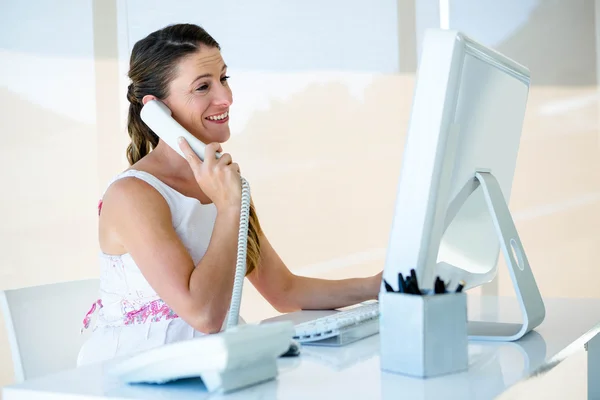 Smilingbusiness žena na telefonu v její kanceláři — Stock fotografie