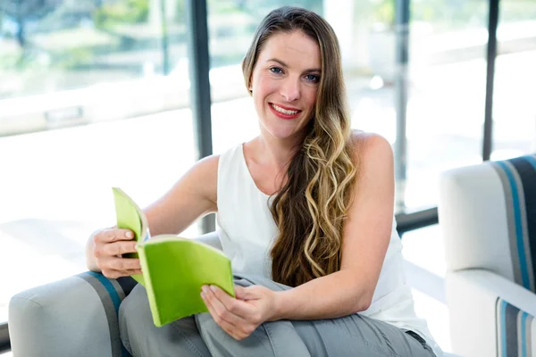 Χαμογελαστή γυναίκα διαβάζοντας ένα βιβλίο — Φωτογραφία Αρχείου