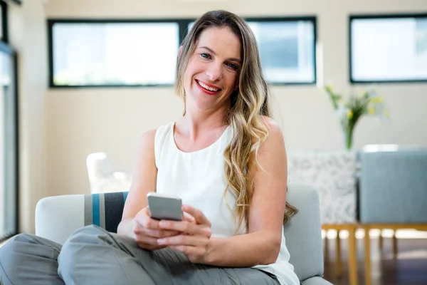 Usmívající se žena na její mobilní telefon — Stock fotografie