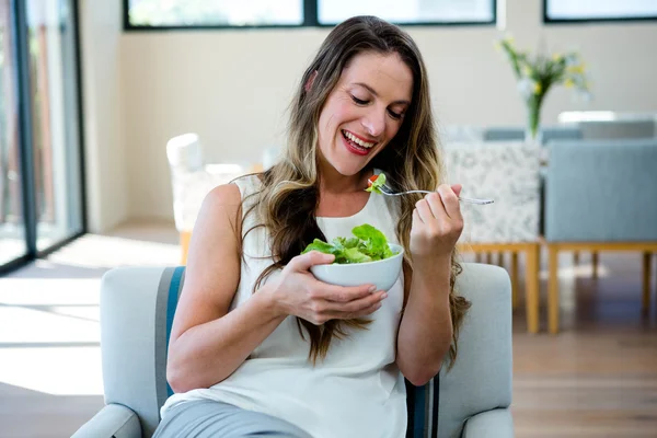 Усміхнена жінка їсть салат — стокове фото