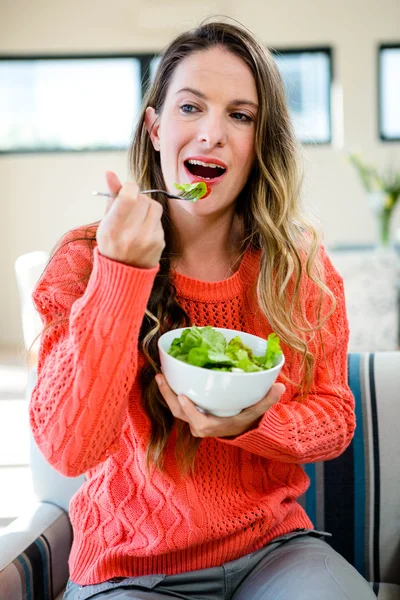 Leende kvinna äta en skål med sallad — Stockfoto