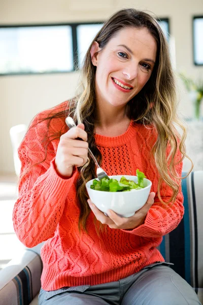 Lächelnde Frau isst eine Schüssel Salat — Stockfoto