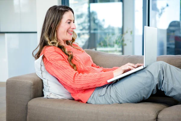 Usmívající se žena psaní na její laptop — Stock fotografie