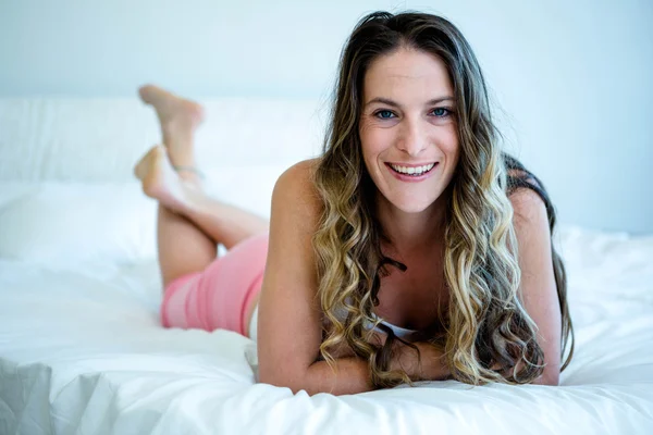 Sorridente donna sdraiata sul suo letto — Foto Stock