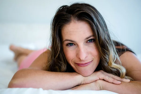 Sorrindo mulher em sua cama — Fotografia de Stock