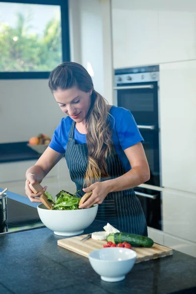 Donna sorridente che lancia un'insalata per cena — Foto Stock