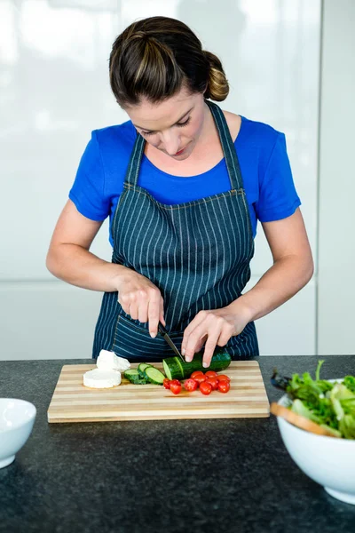 Kvinna som förbereder skivade grönsaker till middag — Stockfoto