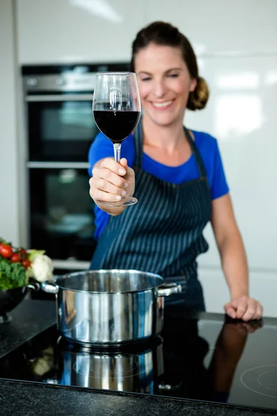 Улыбающаяся женщина готовит на плите — стоковое фото