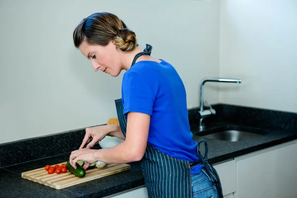 Glückliche Frau bereitet etwas Gemüse zu — Stockfoto