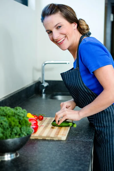 Femme souriante préparant des légumes pour le dîner — Photo
