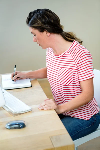 Mulher de negócios escrevendo em seu planejador — Fotografia de Stock