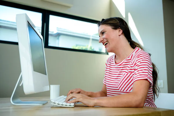 Mulher rindo de seu computador — Fotografia de Stock