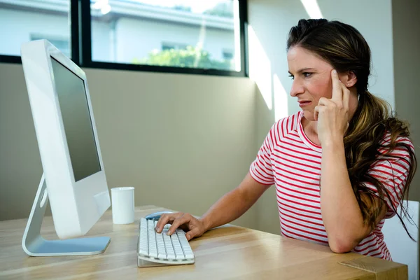 Mujer mirando descontenta sentada en su computadora — Foto de Stock