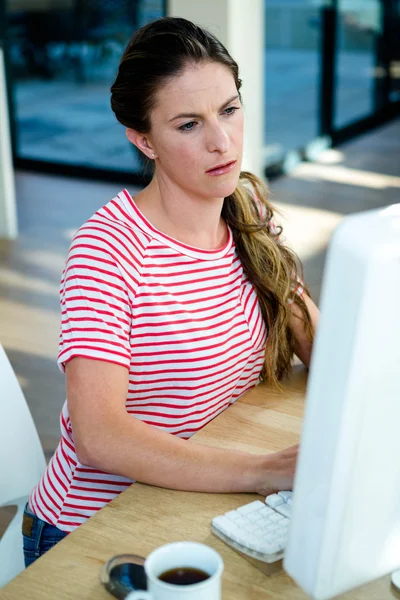 Женщина пристально смотрит на свой компьютер — стоковое фото