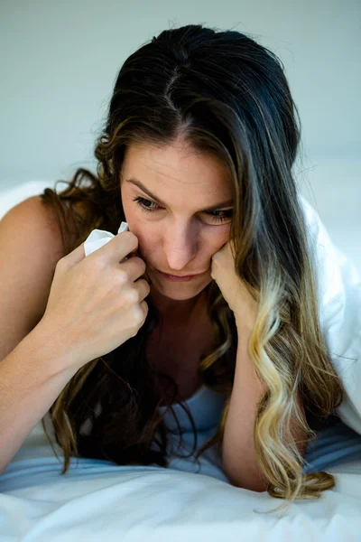 Woman holding a tissue and looking upset — Stock Photo, Image