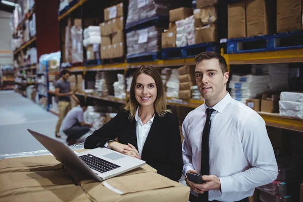 Magazijnbeheerders met behulp van laptop — Stockfoto