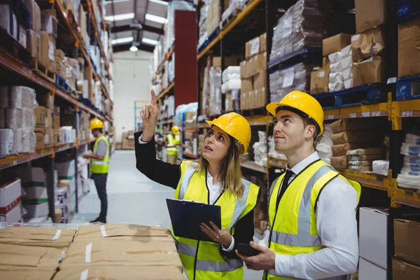 Warehouse managers looking at clipboard — Stock Photo, Image