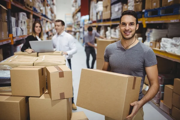 Sonriente hombre llevando caja — Foto de Stock