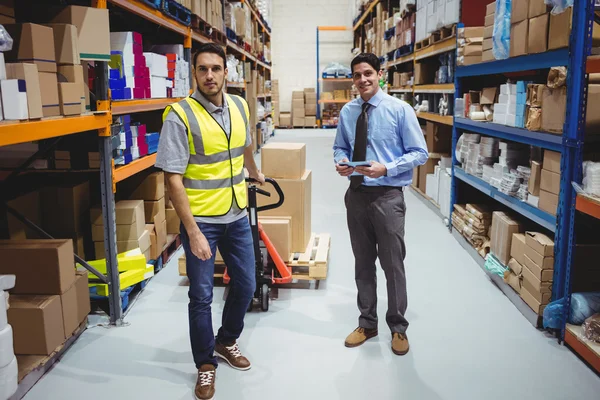 Manager en werknemer trekken trolley — Stockfoto