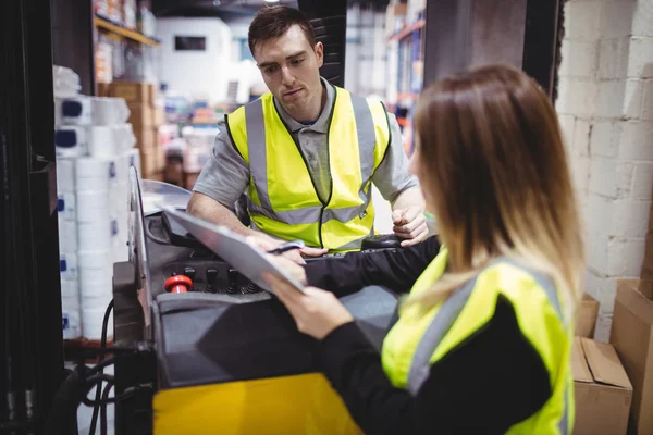 Forklift sürücüsü ile konuşurken depo işçisi — Stok fotoğraf