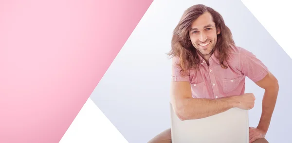 Portrait of hipster smiling while sitting on chair — Stock Photo, Image