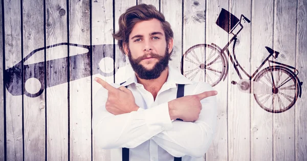 Hipster pointing sideways with arms crossed — Stock Photo, Image
