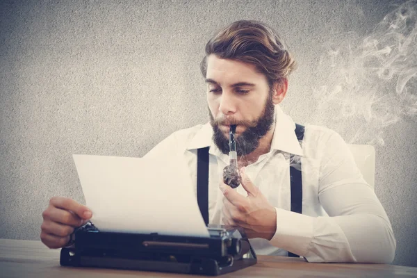 Hipster met rookpijp werken op typemachine — Stockfoto