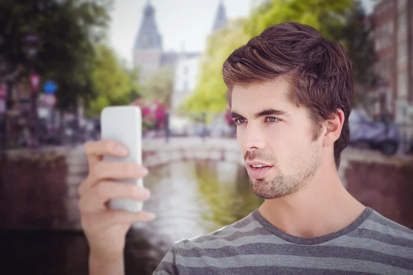 Man op zoek naar mobiele phonewhile staande — Stockfoto