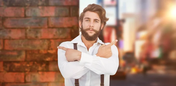 Selbstbewusster Hipster zeigt mit Armen seitwärts — Stockfoto