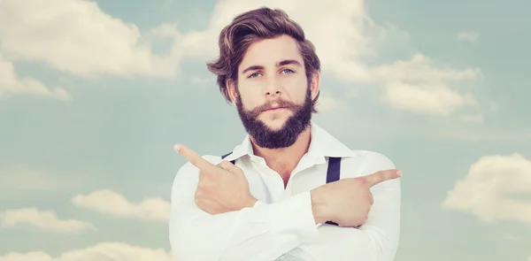 Confident hipster pointing sideways with arms — Stock Photo, Image