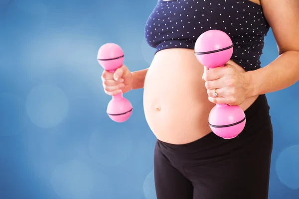 Midsection of pregnant woman lifting dumbbells — Stock Photo, Image