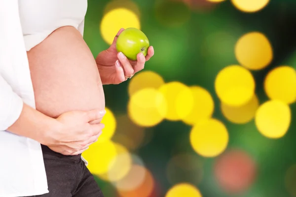 Femme enceinte tenant une pomme verte — Photo