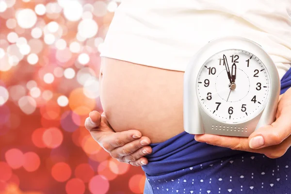 Schwangere zeigt Uhr und Beule — Stockfoto