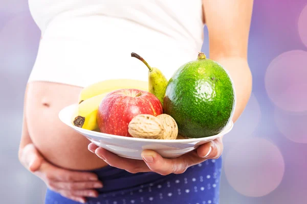 Donna incinta che mostra frutti — Foto Stock