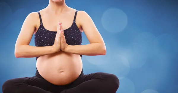 Femme enceinte assise avec les mains jointes — Photo