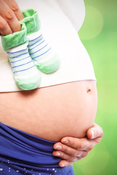 Gravid kvinna med babyskor — Stockfoto