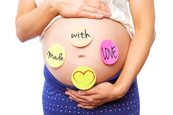 Беременная женщина с наклейками на шишке — стоковое фото