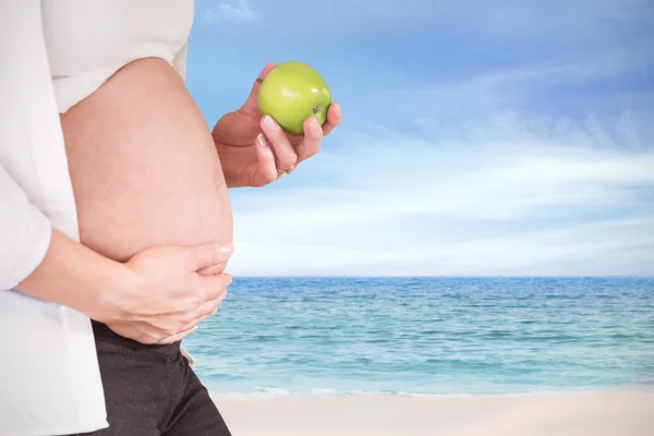 Femme enceinte tenant une pomme verte — Photo